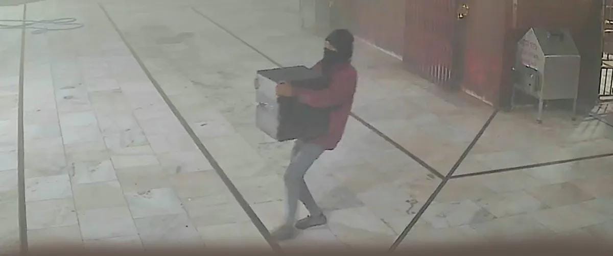 दानपेटी उठाकर ले जाता आदमी