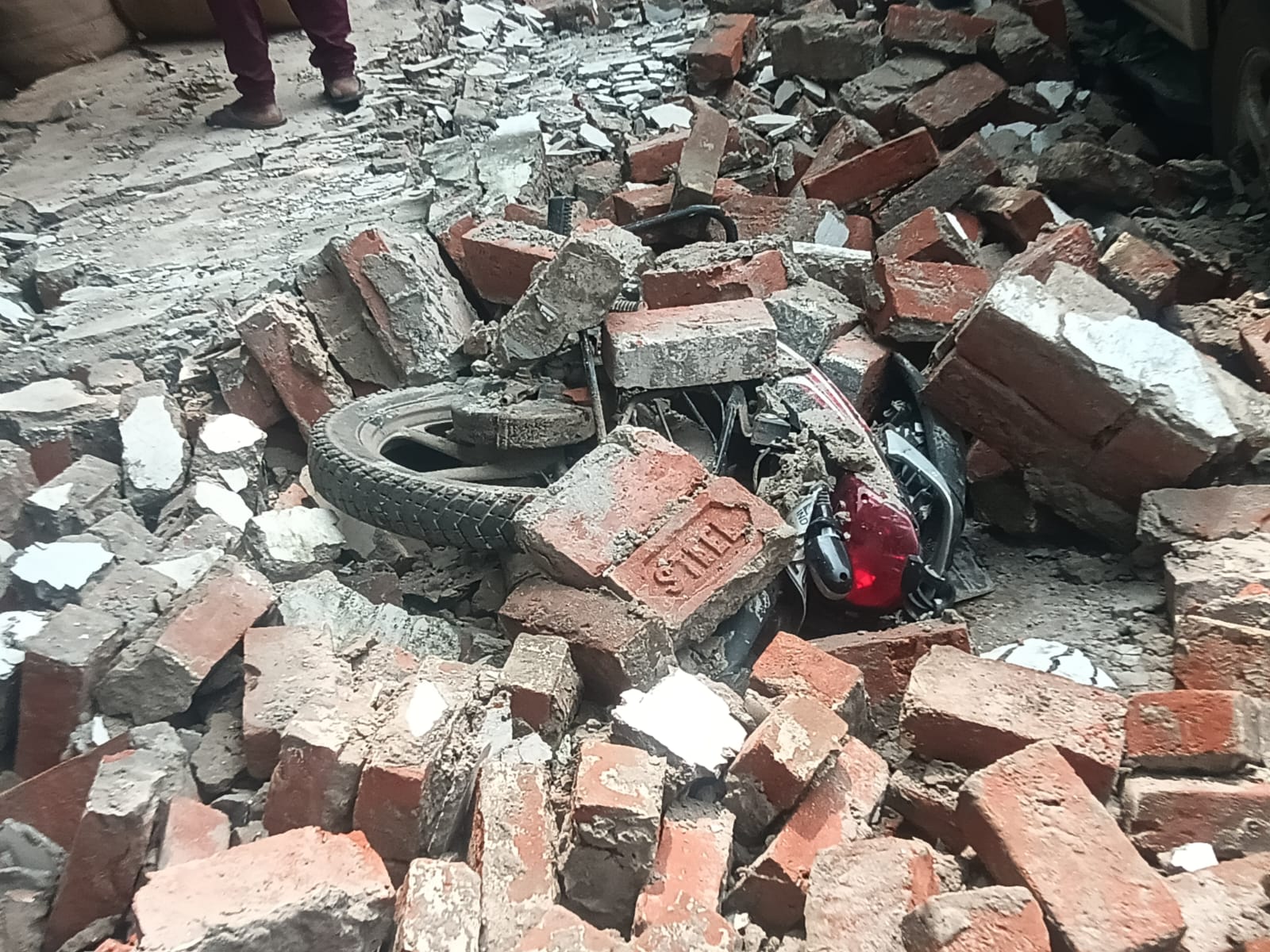 मलबे में दबकर एक मोटरसाइकिल हुई क्षतिग्रस्त मलबे में दबकर एक मोटरसाइकिल हुई क्षतिग्रस्त